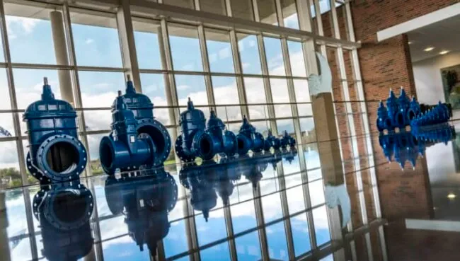 AVK - A group of blue water pipes in front of a large window.
