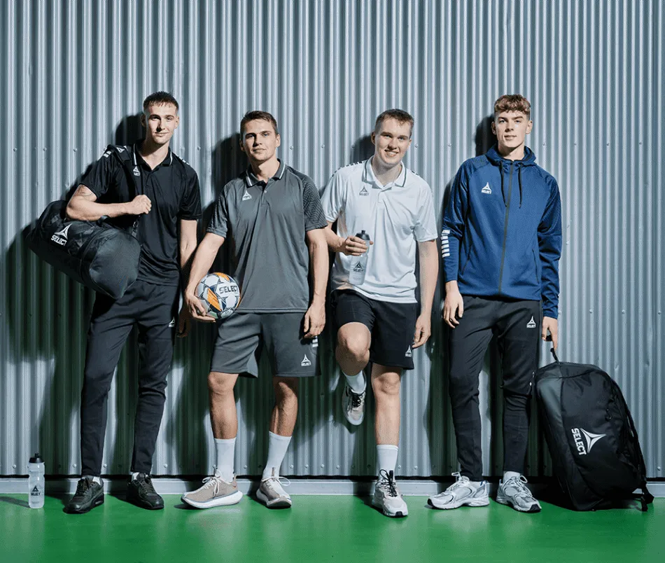 Four men posing with their bags and tennis rackets.