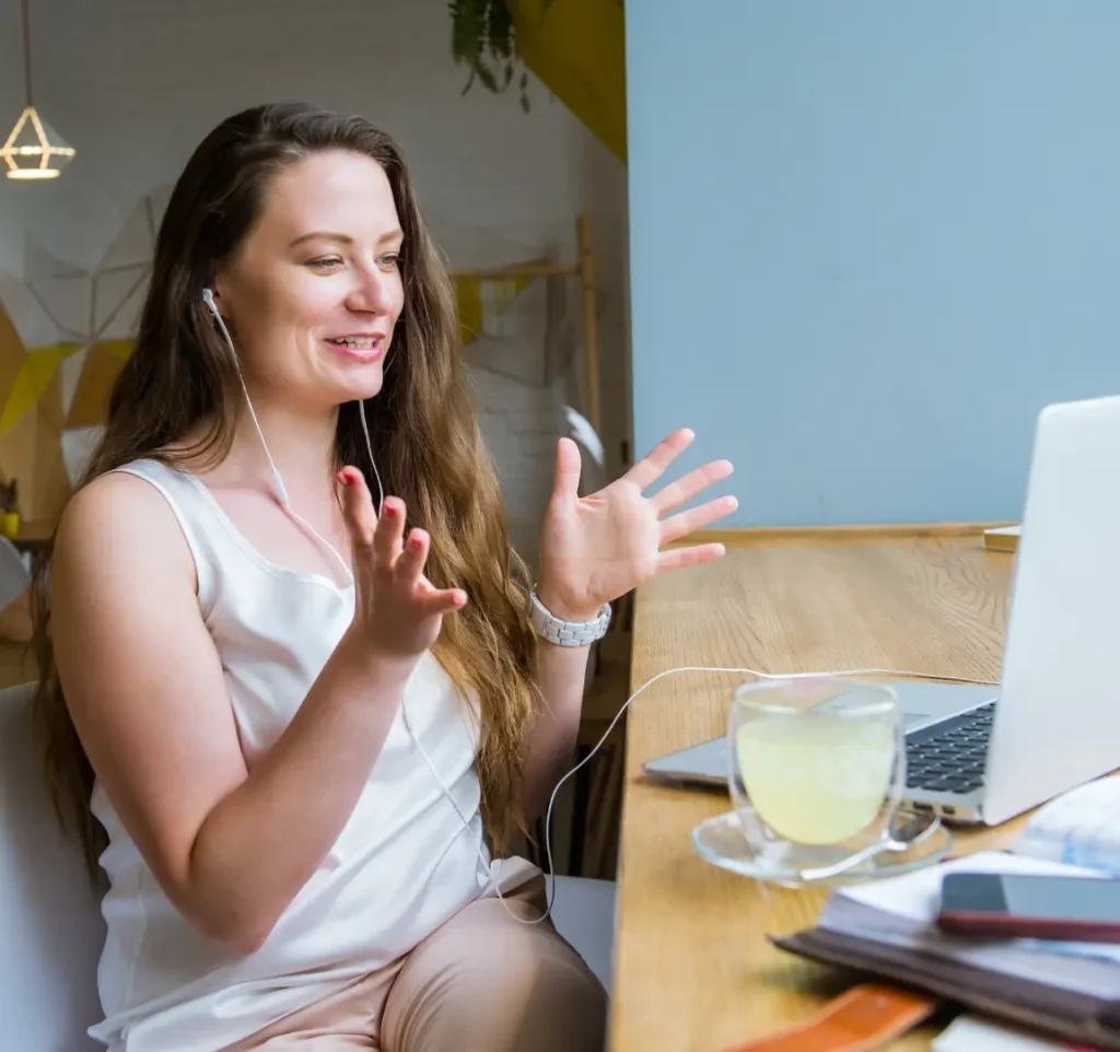 Kontainer DAM Implementation_Change management Woman attending online meeting on her laptop smiling and talking with gesturing hands