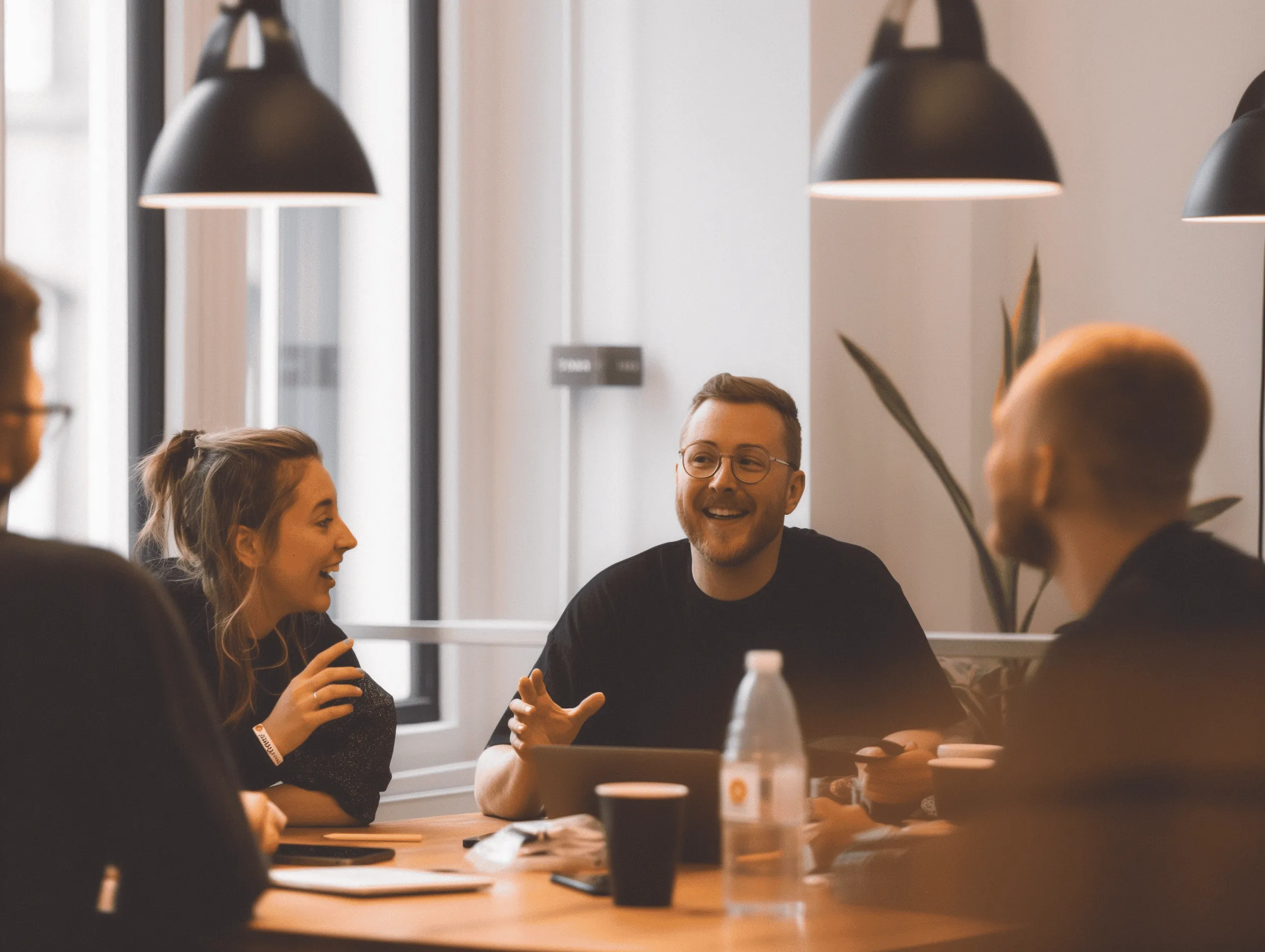 Four people sitting around a table in an office.