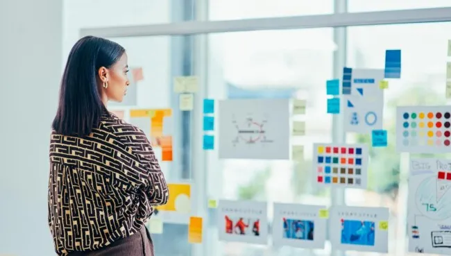 Woman in front of post its on a glass wall