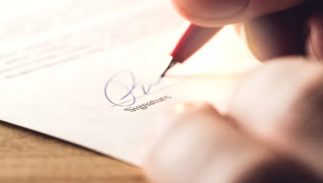 Man writing signature with pen on paper. Settlement for acquisition, business deal, bank loan or rental apartment. Signing contract, agreement, car lease or legal document. The signature is made up.