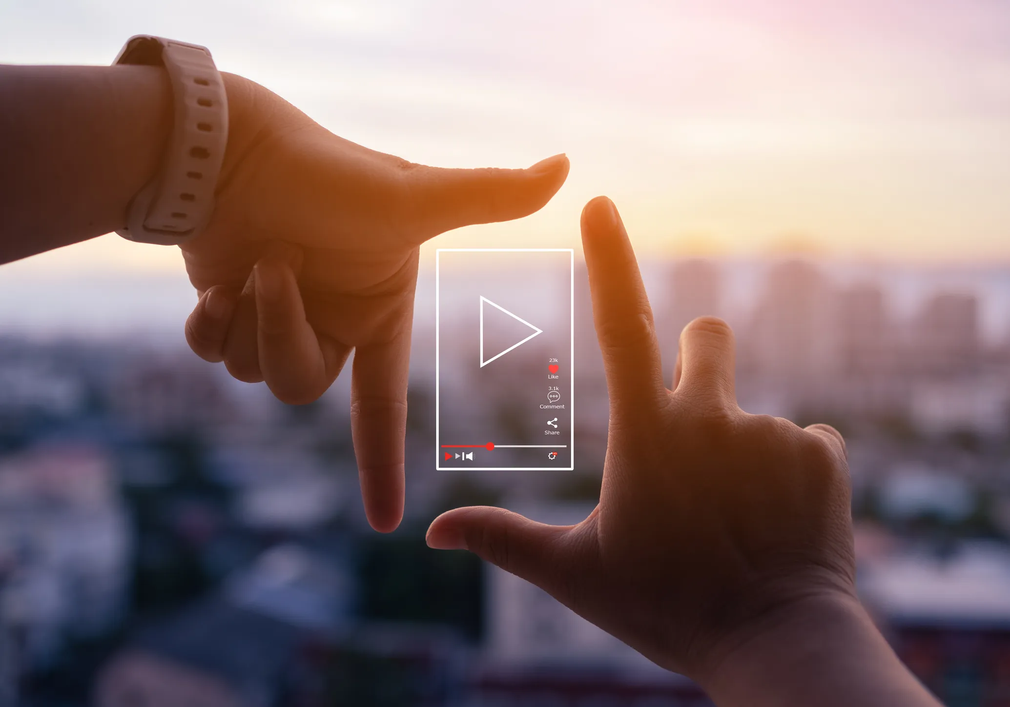 Hände formen ein Play-Symbol vor einem Sonnenuntergang, sinnbildlich für Video-Streaming